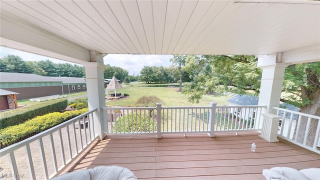 wooden terrace featuring a lawn