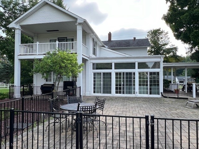 back of property featuring a patio and a balcony