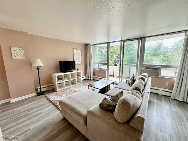 living room with a textured ceiling, hardwood / wood-style flooring, and a baseboard radiator