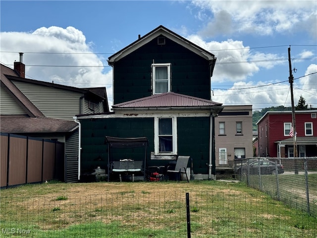 rear view of property with a lawn