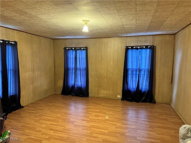 unfurnished room with wooden walls and wood-type flooring