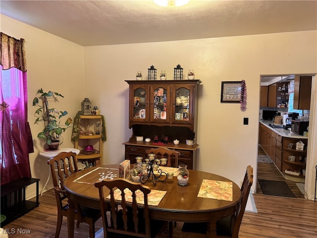 dining space with dark hardwood / wood-style flooring