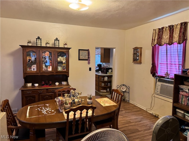 dining area with hardwood / wood-style flooring, a textured ceiling, and cooling unit