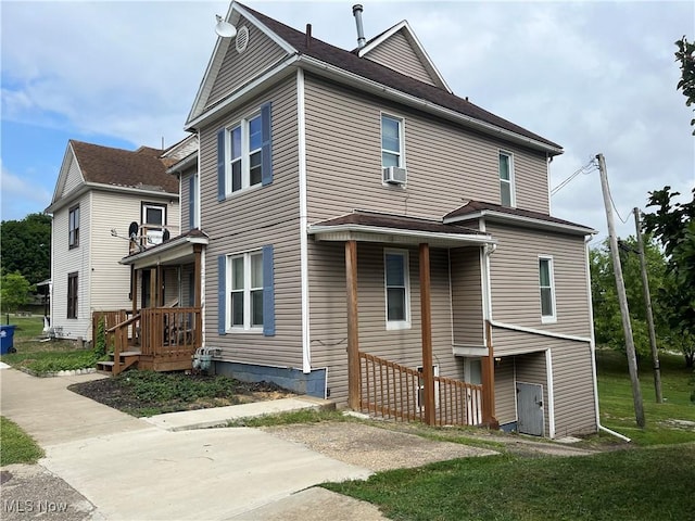 view of front of property with cooling unit and a front lawn