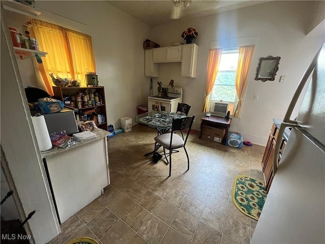 kitchen featuring cooling unit, white cabinets, and white fridge