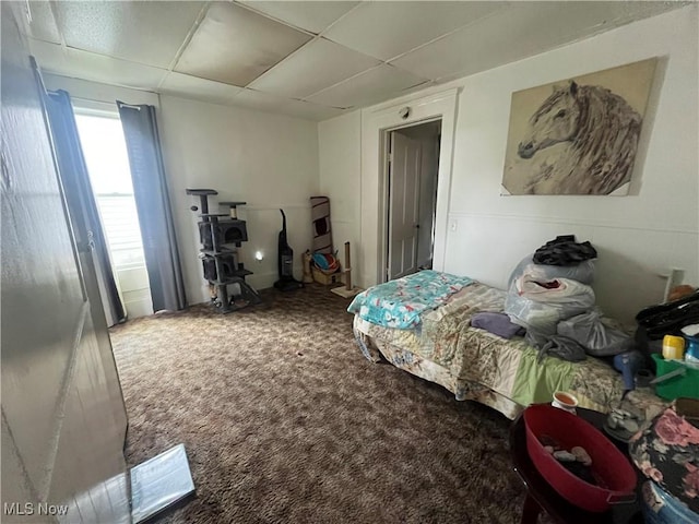 bedroom featuring carpet floors and a drop ceiling