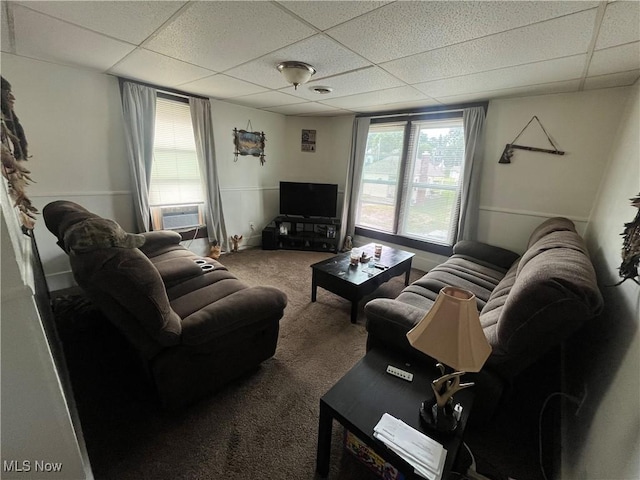 living room with cooling unit, a paneled ceiling, and carpet