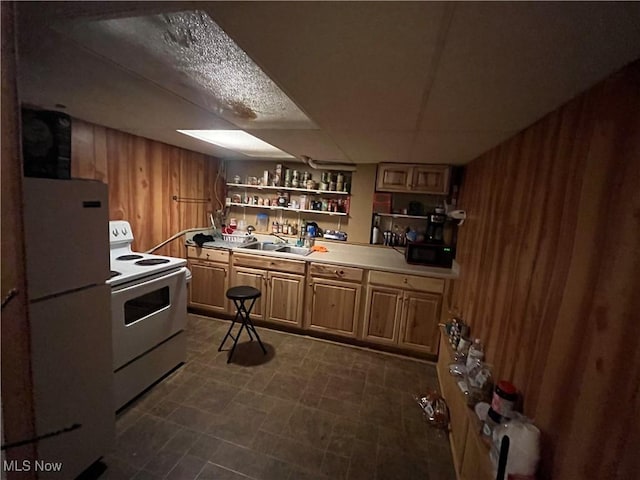 kitchen featuring white appliances, wooden walls, and sink