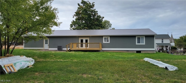 rear view of house with a lawn, french doors, cooling unit, and a deck