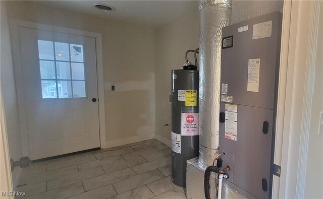 utility room with heating unit and electric water heater