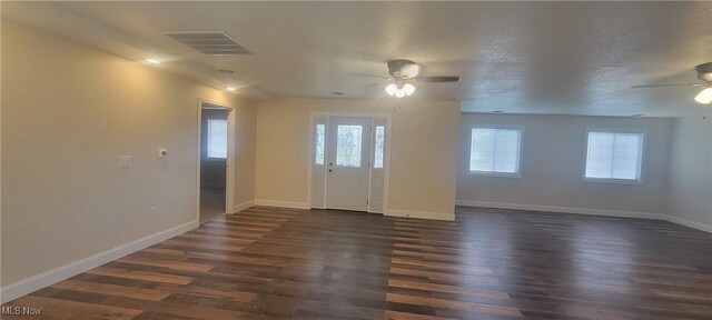 interior space with a textured ceiling, ceiling fan, and dark hardwood / wood-style floors