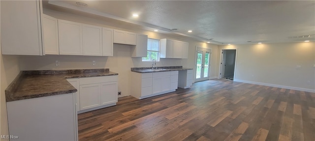 kitchen featuring white cabinets, dark wood-type flooring, and sink