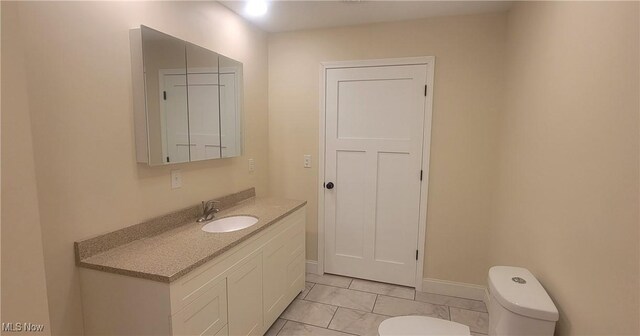 bathroom featuring tile patterned floors, vanity, and toilet