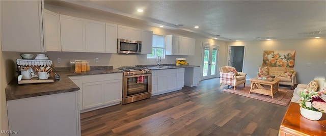 kitchen with white cabinets, appliances with stainless steel finishes, dark wood-type flooring, and sink