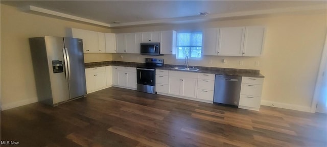 kitchen featuring white cabinets, appliances with stainless steel finishes, dark wood-type flooring, and sink