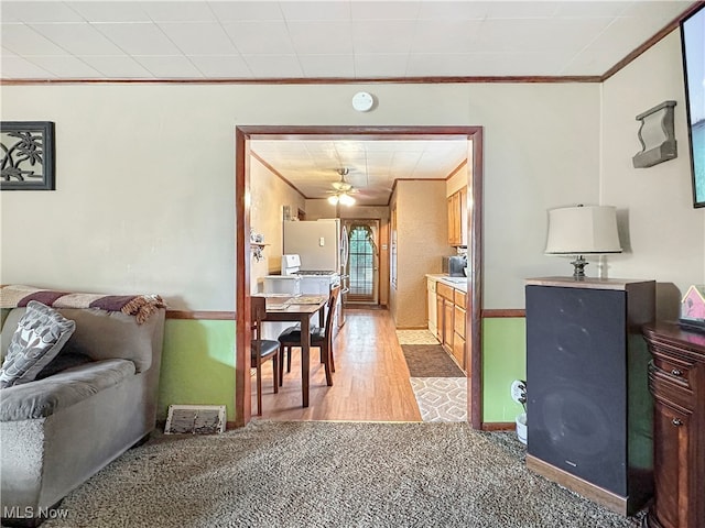 interior space featuring ceiling fan, ornamental molding, and light hardwood / wood-style floors