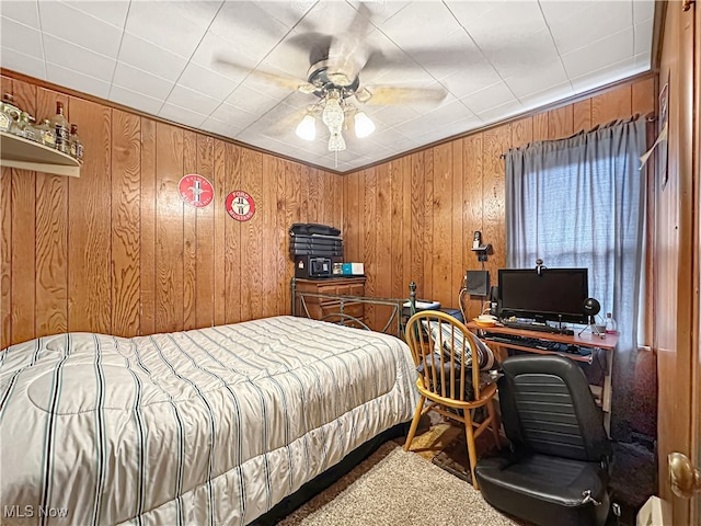 carpeted bedroom with ceiling fan and wooden walls