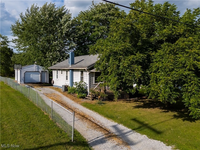 view of front facade featuring an outbuilding, central AC unit, a wooden deck, a garage, and a front yard