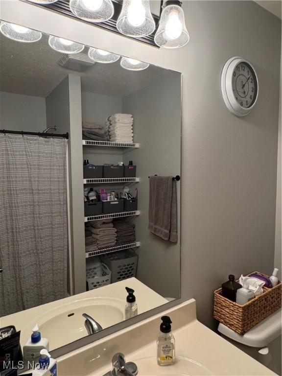 bathroom featuring walk in shower and sink