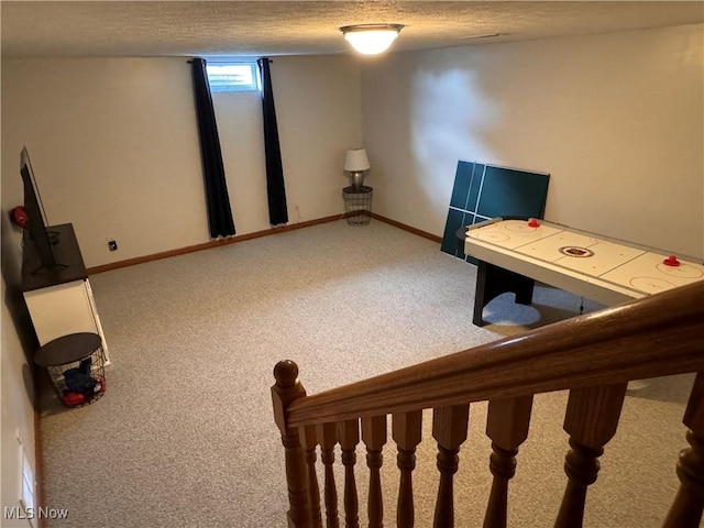 game room featuring carpet floors and a textured ceiling