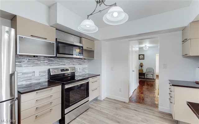 kitchen featuring stainless steel appliances, light hardwood / wood-style flooring, pendant lighting, and decorative backsplash