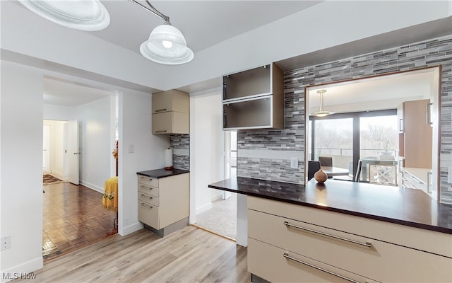 kitchen with backsplash, hanging light fixtures, and light hardwood / wood-style floors