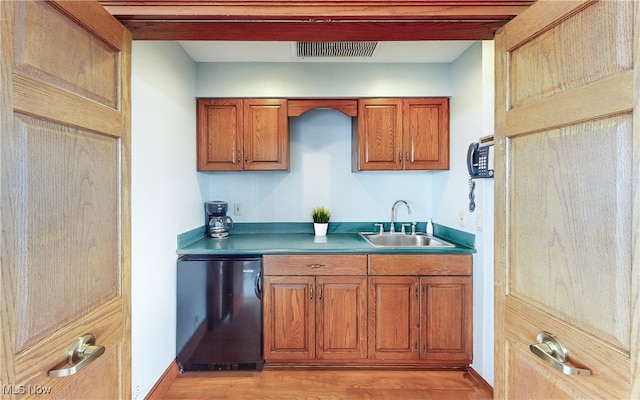 bar featuring visible vents, fridge, light wood-style floors, baseboards, and a sink