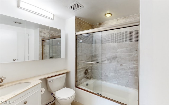 bathroom featuring enclosed tub / shower combo, toilet, visible vents, and vanity