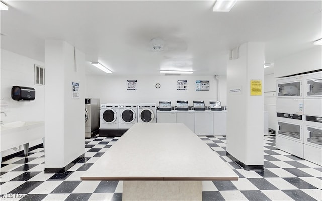 interior space featuring dark tile patterned flooring, stacked washing maching and dryer, and independent washer and dryer