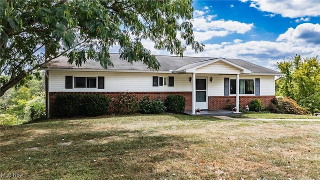 ranch-style house with covered porch, a front yard, and brick siding