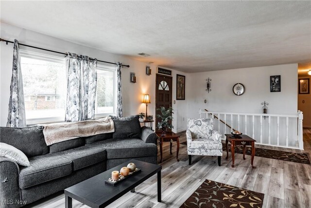 living room featuring a textured ceiling and light hardwood / wood-style floors