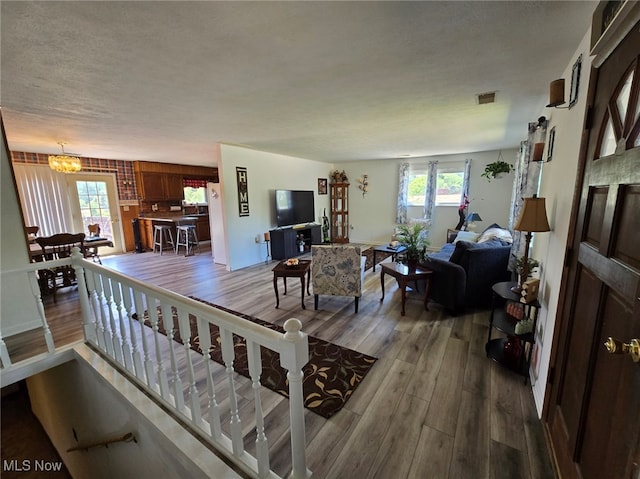 living room with plenty of natural light, hardwood / wood-style floors, and a chandelier