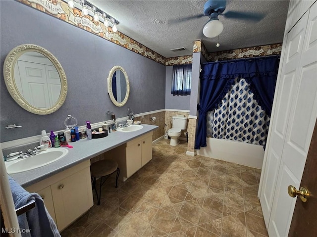 full bathroom with vanity, toilet, shower / tub combo, and a textured ceiling