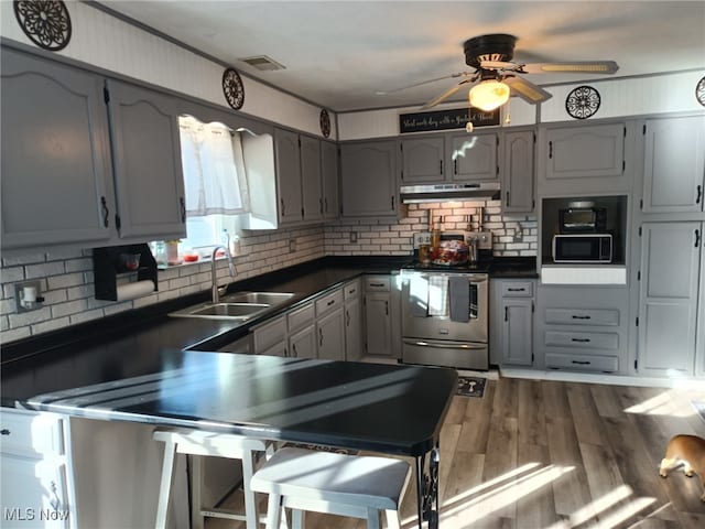 kitchen featuring built in microwave, tasteful backsplash, sink, and stainless steel electric range