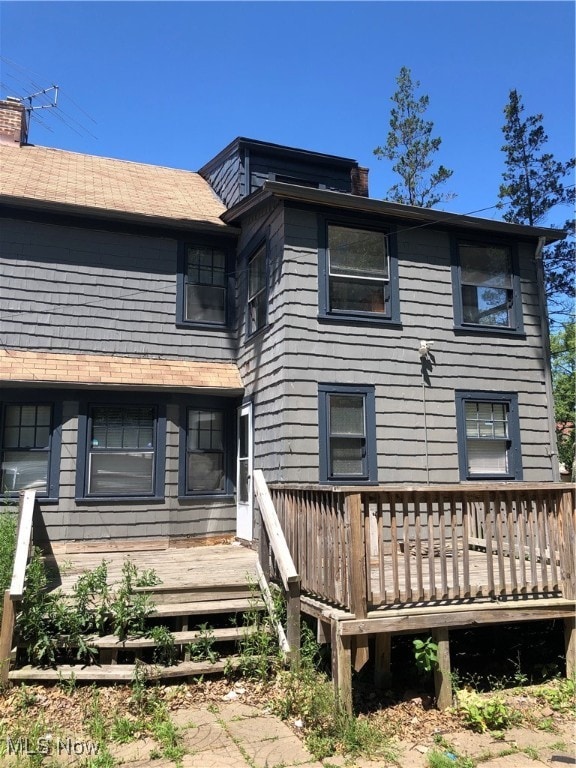 rear view of property featuring a wooden deck