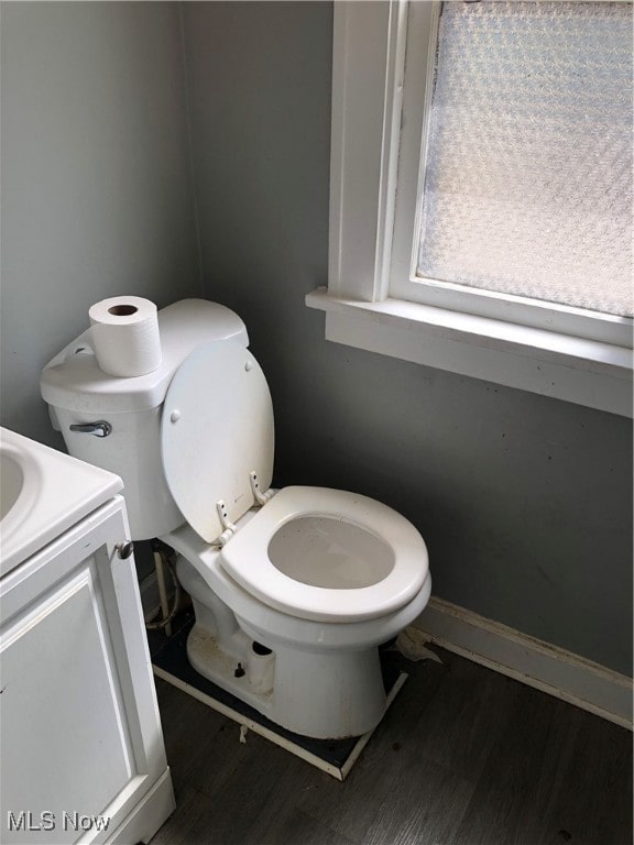 bathroom with vanity, toilet, and hardwood / wood-style floors