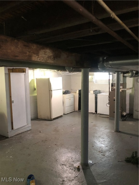 basement with white refrigerator and washer and clothes dryer