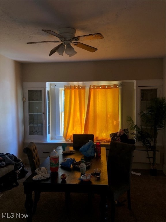 dining space with ceiling fan and carpet