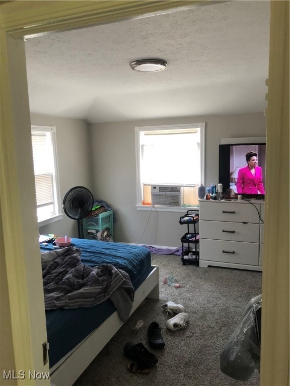 carpeted bedroom with cooling unit and a textured ceiling