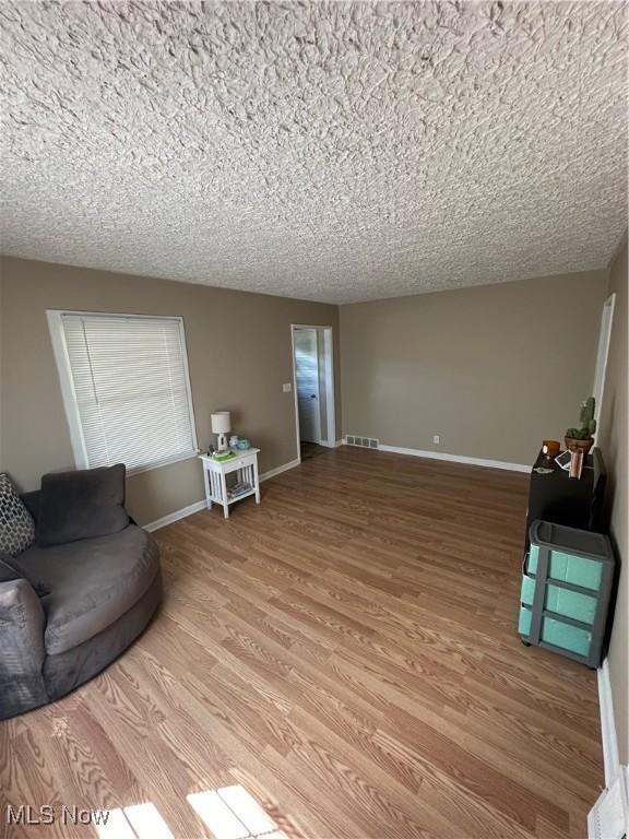 living room with a textured ceiling and wood-type flooring