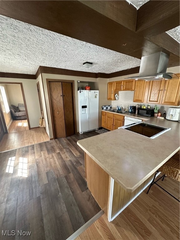 kitchen featuring hardwood / wood-style flooring, white fridge with ice dispenser, island exhaust hood, and a textured ceiling