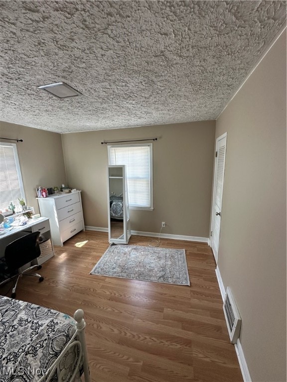 bedroom featuring a textured ceiling and hardwood / wood-style flooring