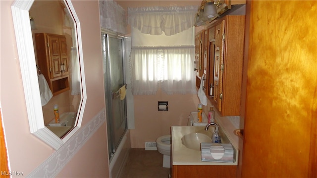 full bathroom featuring enclosed tub / shower combo, toilet, and vanity