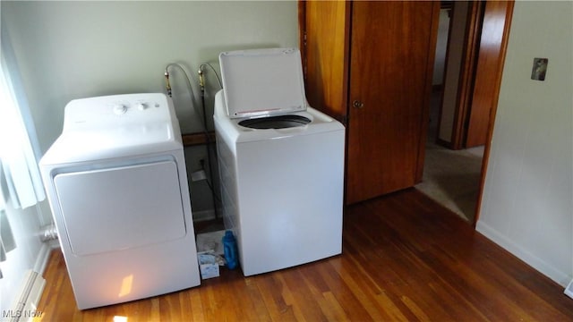 clothes washing area with dark wood-type flooring and separate washer and dryer