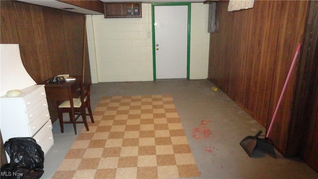 basement featuring wooden walls