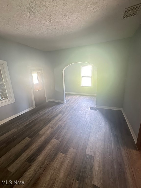 unfurnished room with wood-type flooring and a textured ceiling