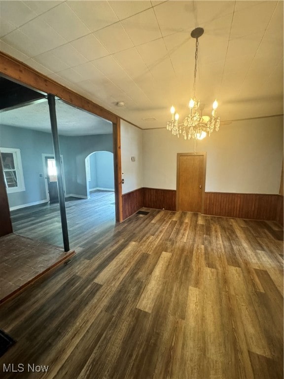 spare room featuring hardwood / wood-style flooring and an inviting chandelier