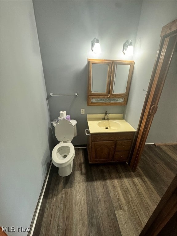 bathroom featuring vanity, toilet, and hardwood / wood-style flooring