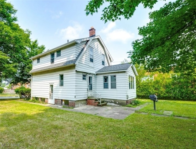 rear view of house featuring a yard