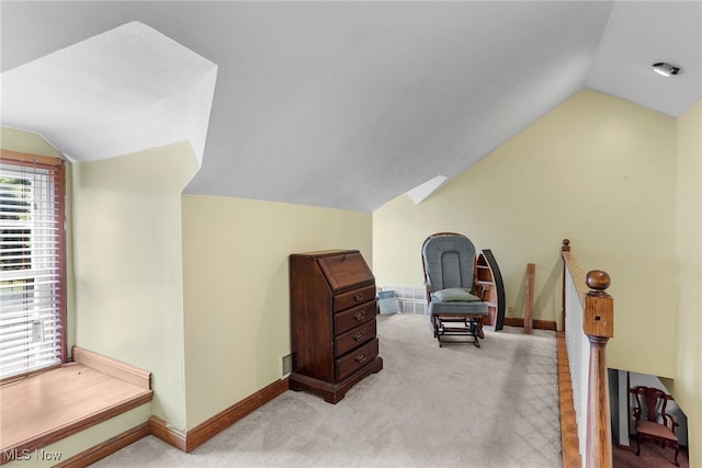 sitting room featuring light colored carpet and vaulted ceiling